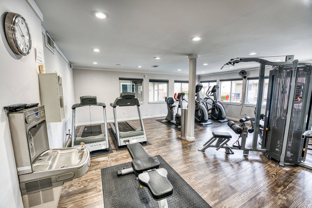 a gym with cardio equipment and weights on the floor at Juniper Springs Apartments, Austin, TX